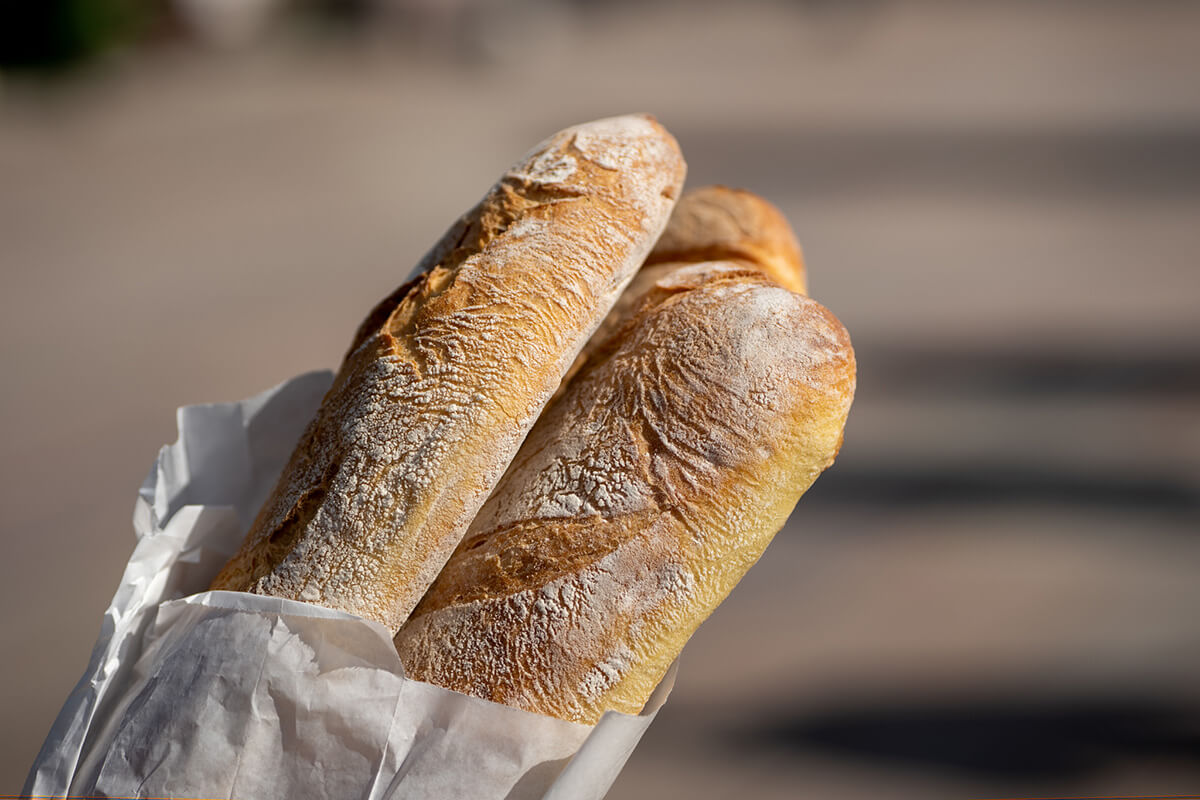 Frisches Brot in einer Papiertüte, mit knuspriger Kruste und goldenem Inneren.