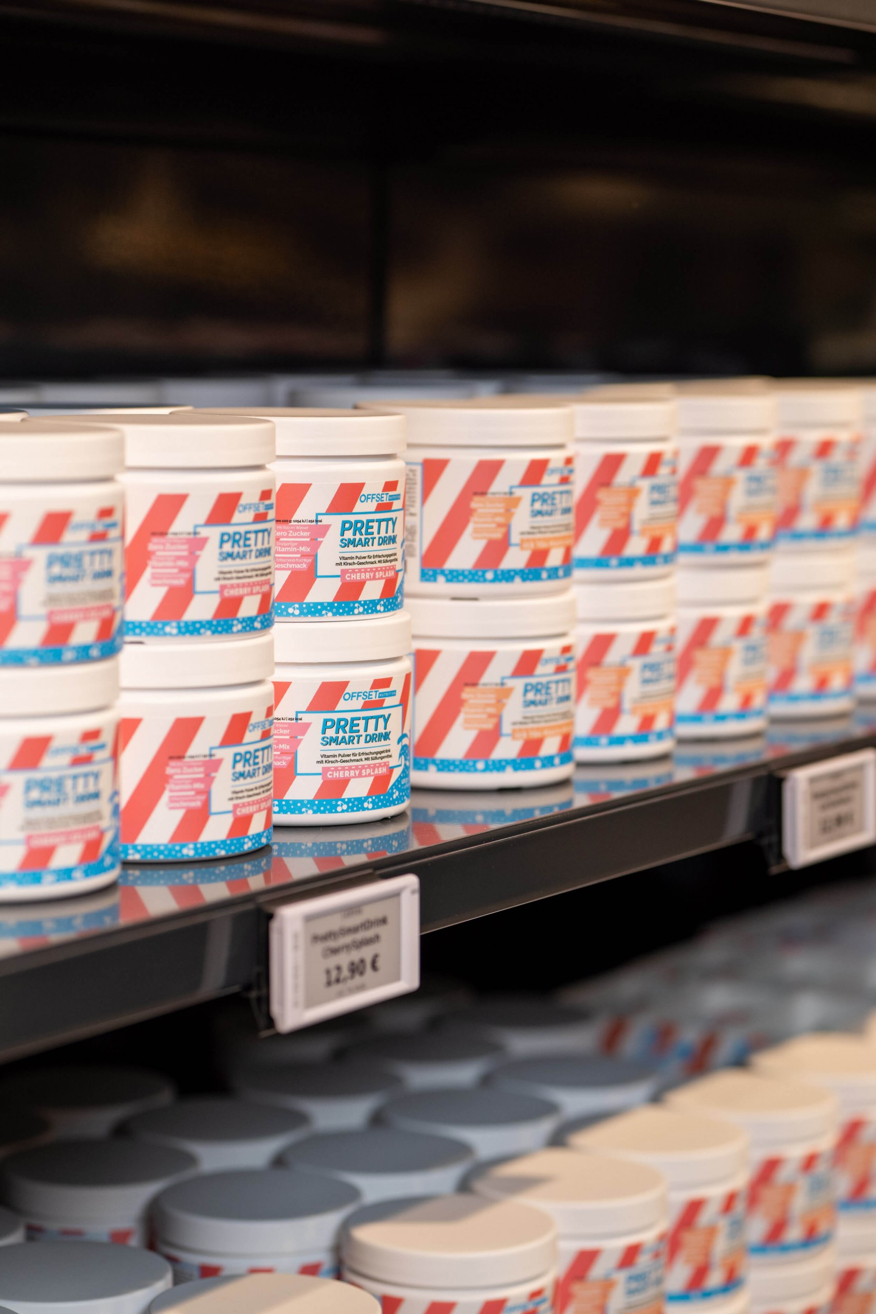 Regal mit mehreren Dosen eines Getränkepulvers in auffälliger Verpackung.