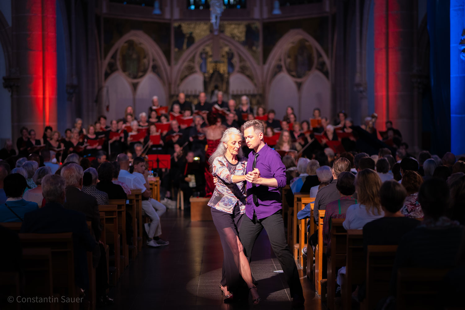 Tanzende Paare in einer beschlossenen Kirche vor einem Chor, festliche Atmosphäre.