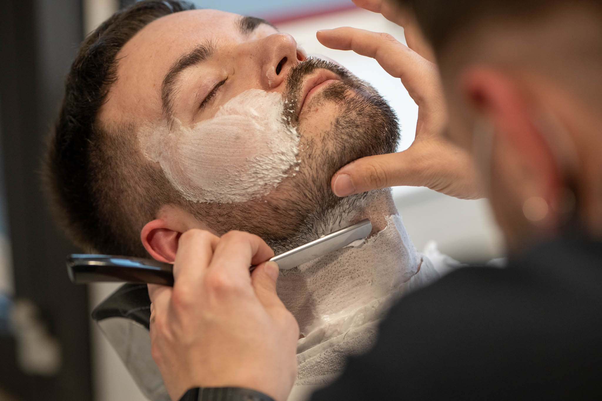 Ein Mann erhält eine Rasur mit einem Rasiermesser in einem Barbershop.