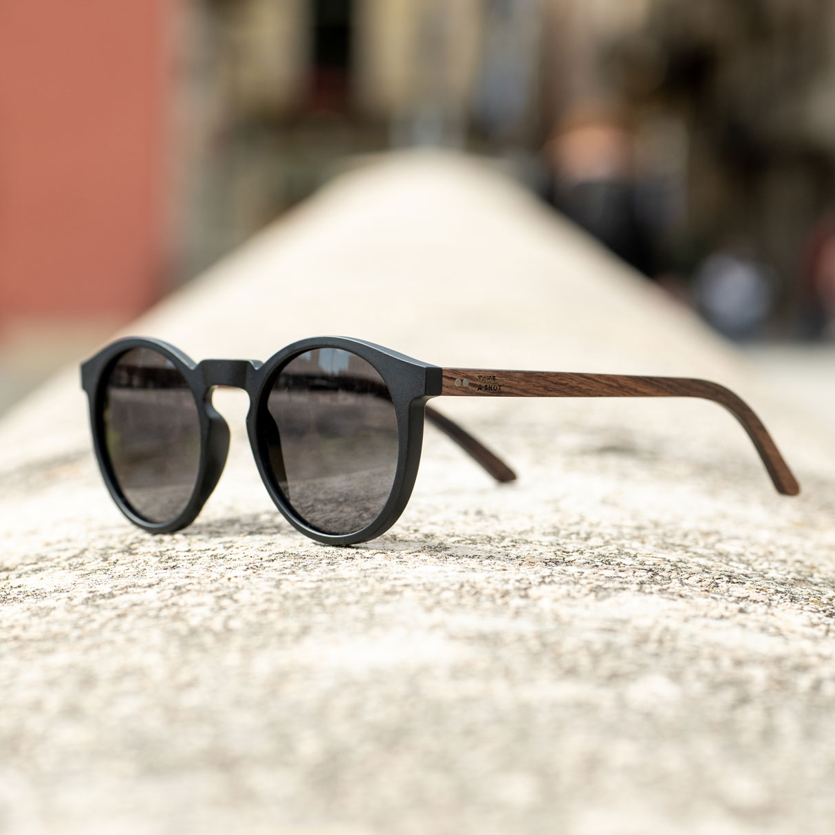Stylische Sonnenbrille mit schwarzen Gläsern und Holz-Design.